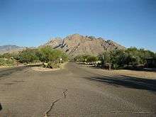 Mountains rise in the background of a photo from a residential area in Oro Valley.