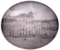 Photograph showing the Imperial Palace in Rio de Janeiro with carriages and mounted honor guard in the square fronting the palace.