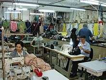 People at sewing machines in a small garment factory