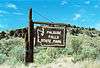 A sign stating "Palouse Falls State Park" in an arid landscape