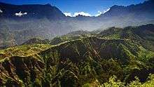 Jagged, green mountains against a blue sky