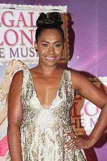 Color photograph of a brown woman wearing a blue dress.