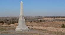 Stone obelisk, 10-12 feet tall, on ridge overlooking plain