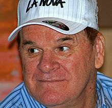 A wide-faced man wearing a white baseball cap