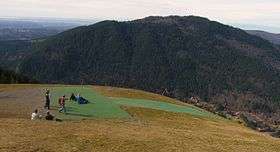 View from the top of a tall hill overlooking more hills