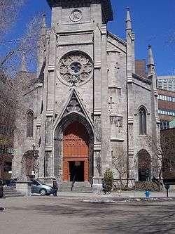 Large brown doors set in a large gray brick facade.