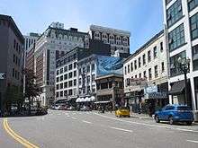 Wide downtown street, with Mary's Club in the middle of the block