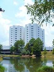 Ground-level view of an 11-story hospital building with a white facade.