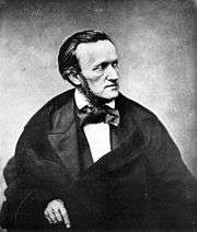 A photograph of the upper half of a man of about fifty viewed from his front right. He wears a cravat and frock coat. He has long sideburns and his dark hair is receding at the temples.