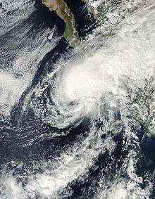 Satellite image of a more poorly organized and less intense storm. Thunderstorms no longer surround the center, and are instead concentrated on the northeastern side of the circulation. The hurricane is approaching land.