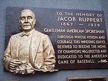 A plaque commemorating Jacob Ruppert, which reads: "Gentleman, American, Sportsman: Through whose vision and courage this imposing edifice, destined to become home of champions, was erected and dedicated to the American game of baseball"