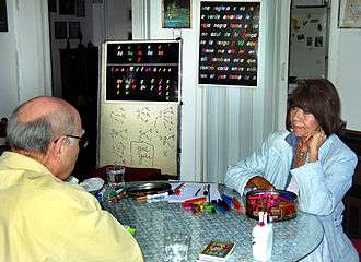 A teacher and student sit opposite one another in a small language classroom