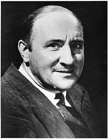 Head and shoulders of smiling man in a suit and tie