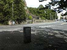 A photograph of a freestanding plaque next to a road junction