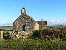 A stone very simple church see from the west end. The only features are a small round-headed door, a small bellcote, and a tiny rectangular window