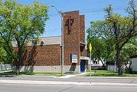 A two-storey brown brick church with a modern bell tower.