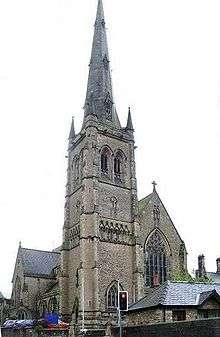 A stone Gothic style church with a tall steeple