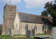 Stone building with square tower.