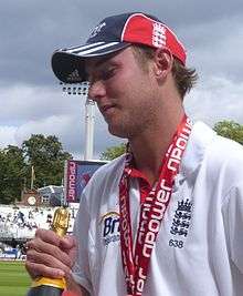 A side shoot of a white-skinned man holding a champagne bottle in his hand