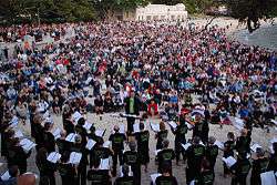 Choir on a beach with conductor and audience