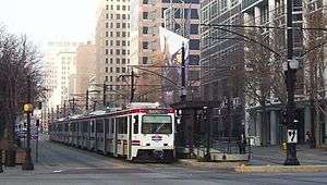 A light-rail train surrounded by tall buildings