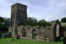 The ruins of a church seen from the southeast. Still standing are the tower, the south wall, with three windows, and the east end; there are no roofs