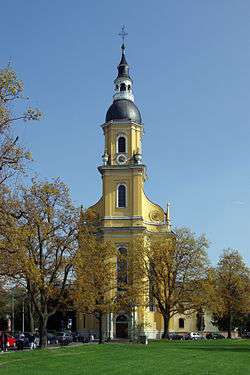 Almost straight-on view of the muted yellow, narrow, tall tower entrance of Saint Paulinus' Church