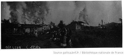 Burning buildings, with residents watching