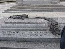 A granite tomb engraved with The Unknown Soldier on the side; a bronze relief sculpture is atop the sarcophagus