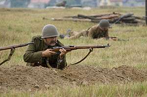 A soldier levels rifle