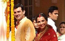 Vidya Balan and Siddharth Roy Kapur are smiling at the camera.