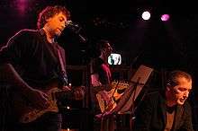 A photo showing Yann Tiersen (on the left) and Christophe Miossec (on the right) live in concert at Cabaret Vauban, Brest, France, on 6 February 2005.